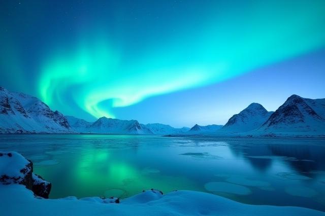 Et storslått arktisk landskap med Nordlys over fjell og fjord